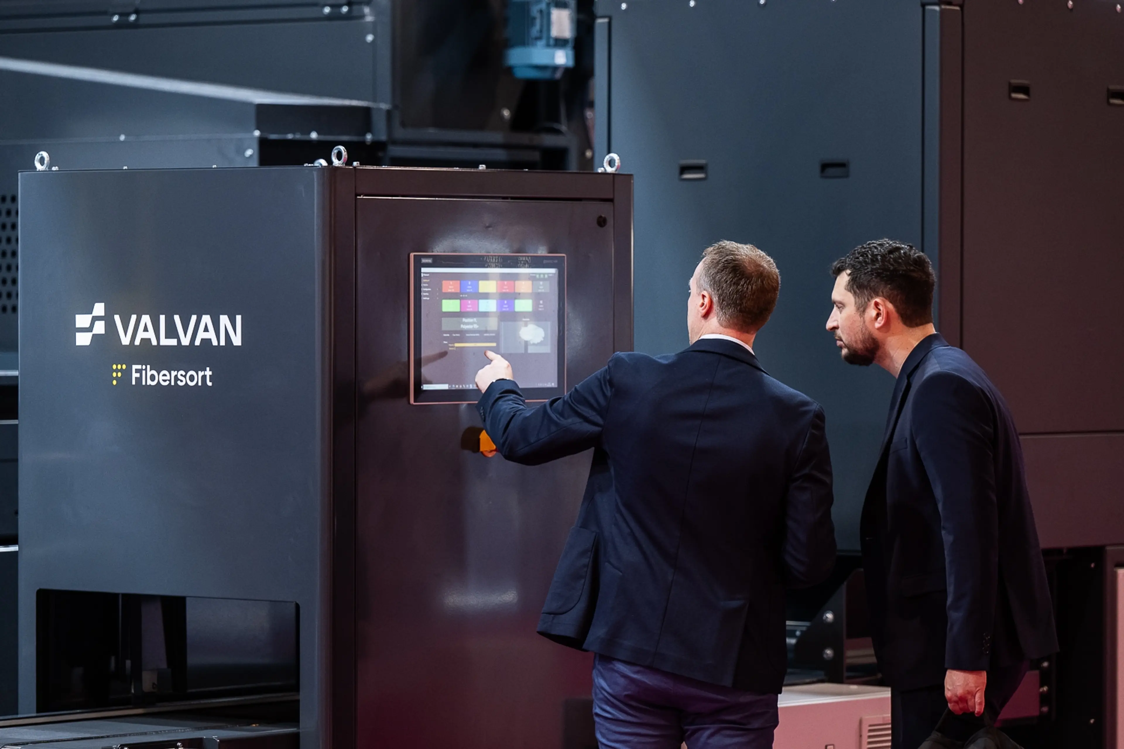Two men talking at Valvan exhibition stand AMI's Textiles Recycling Expo Europe 2025